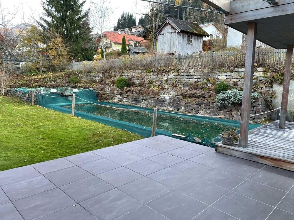 Biopool im Herbst mit Schutznetz, Terrasse und Natursteinmauer