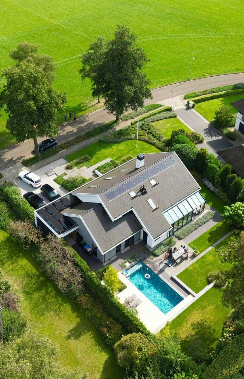 Luftaufnahme von Designpool und Einfamilienhaus im gepflegten Garten