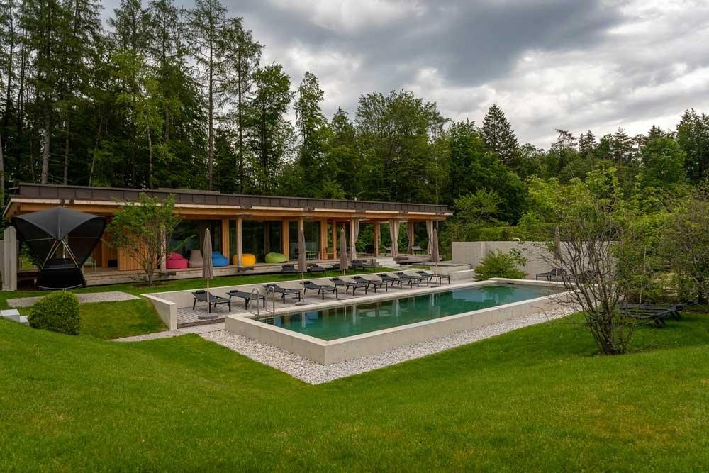 Großer Biopool im Hotelgarten mit Liegen und moderner Architektur