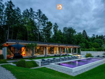 Großer Biopool im Hotelgarten mit Liegen und moderner Architektur