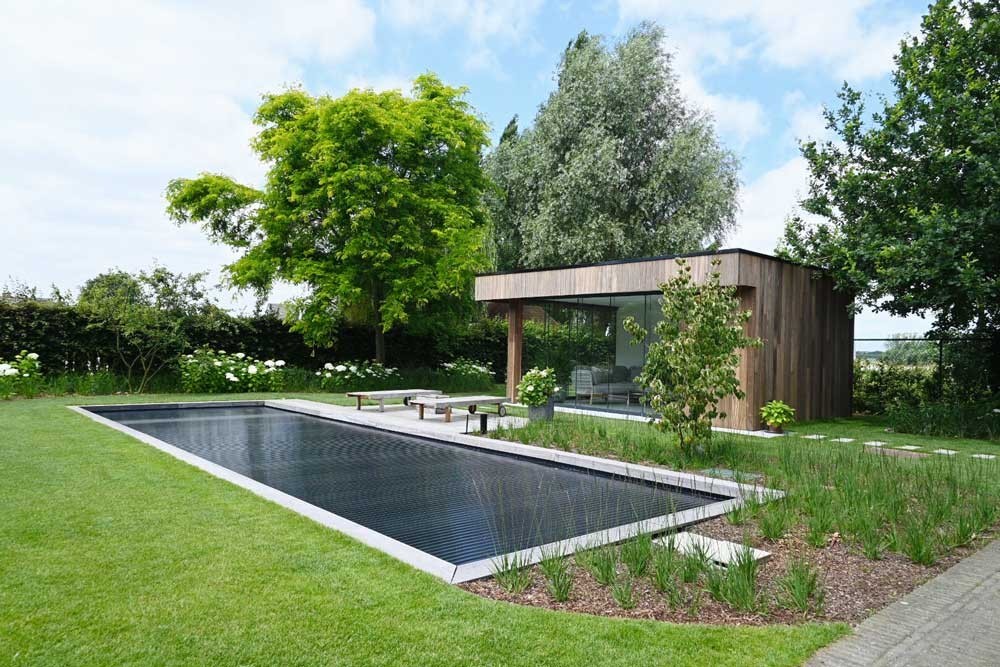 Biotop Living Pool mit moderner Terrasse und Poolhaus in einem stilvollen Garten