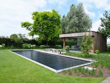 Biotop Living Pool mit moderner Terrasse und Poolhaus in einem stilvollen Garten