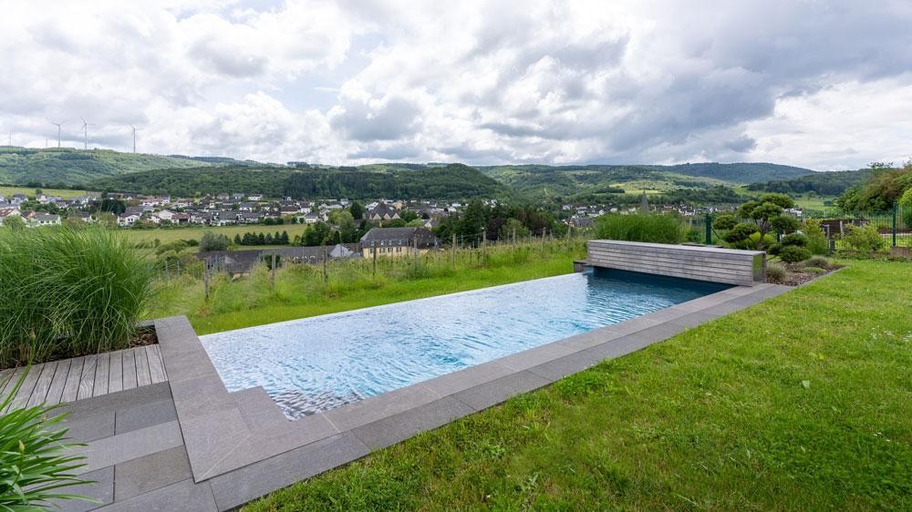 Naturpool in Hanglage mit Weitblick auf Landschaft und Ortschaft