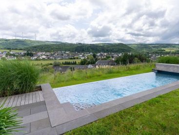 Naturpool in Hanglage mit Weitblick auf Landschaft und Ortschaft