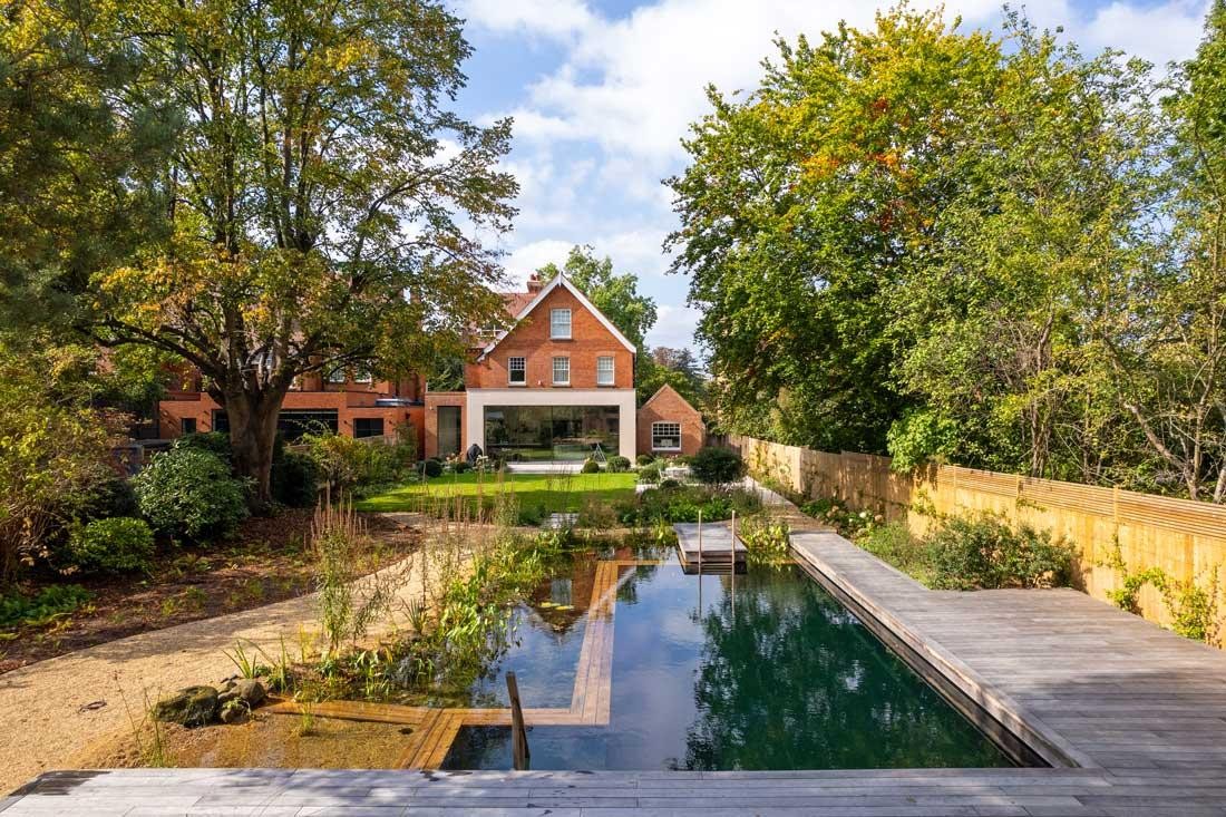 Naturpool mit Holzdeck und Gartenhaus im naturnahen Garten