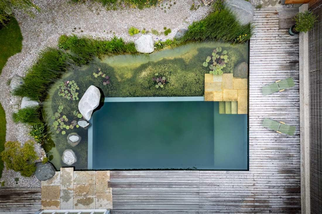 Luftaufnahme eines Naturpools mit Regenerationszone und Holzdeck