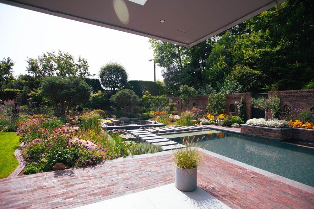 Naturpool mit Terrasse Seerosen und naturnaher Bepflanzung