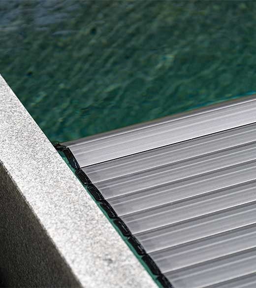 Detail einer Poolabdeckung die auf dem Wasser schwebt bei einem Granitpool