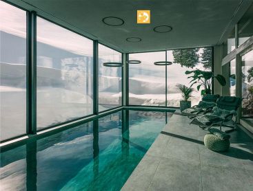 Living Pool im Innenbereich mit Panoramablick auf Schneeberge