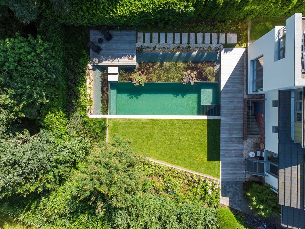 Luftaufnahme eines Naturpools mit Regenerationszone am modernen Hausgarten
