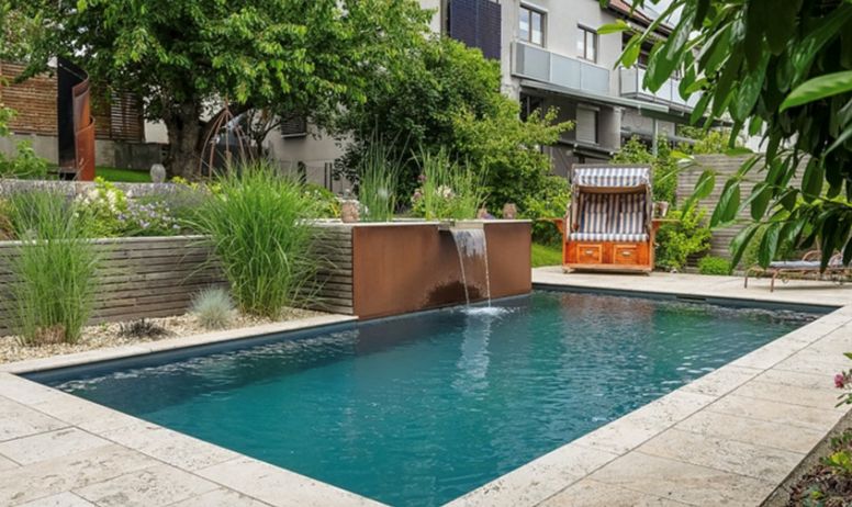 Gartenpool mit Wasserfall und moderner Bepflanzung Moderner Gartenpool mit Wasser umgeben von Pflanzen und Wasserfall Element
