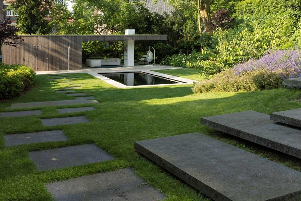 Naturpool mit Terrasse, Rasenfläche und blühender Gartengestaltung