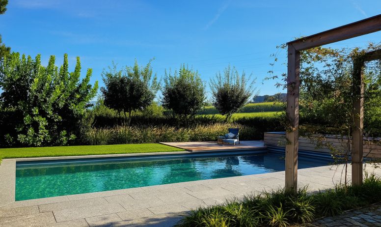 Moderner Living Pool in exklusiver Gartenanlage Moderner Naturpool umgeben von hochwertiger Gartenarchitektur