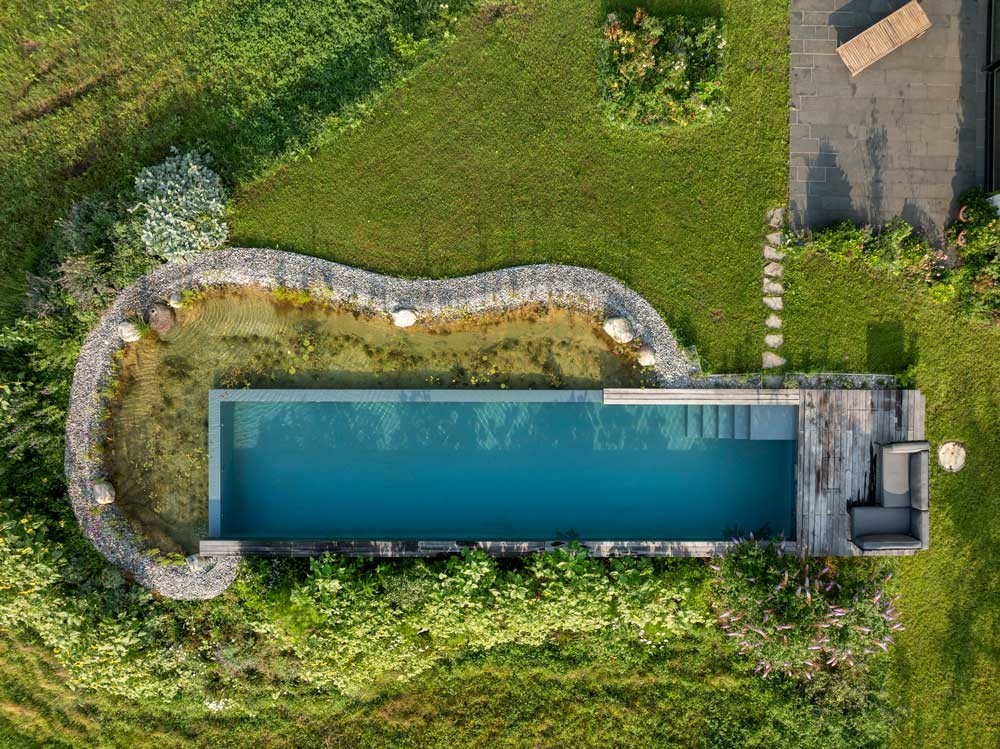 Moderner Swimming Pond mit Infinity Charakter und Regenerationszone aus der Vogelperspektive
